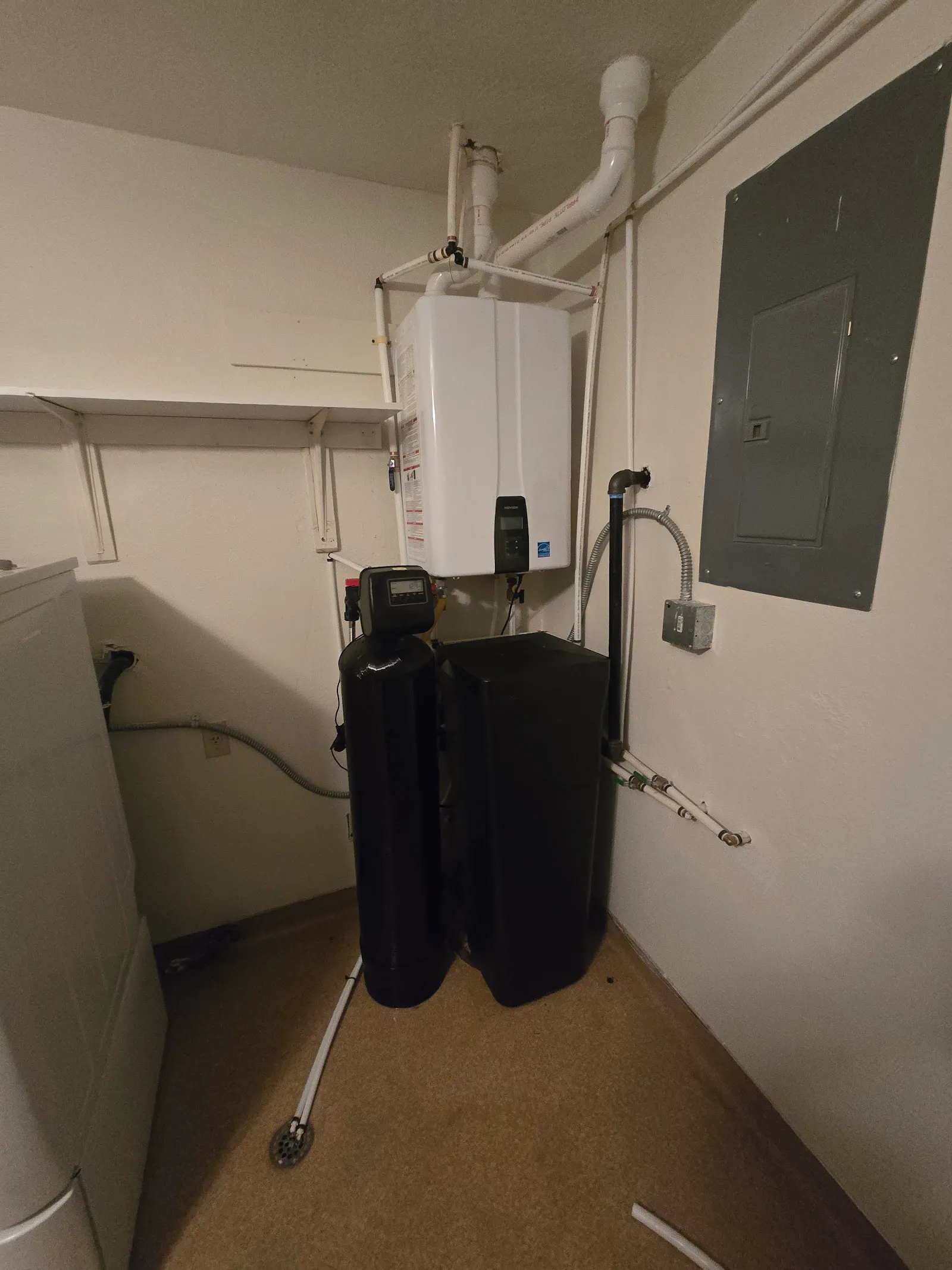 Water softener system and tankless water heater installed in a utility room